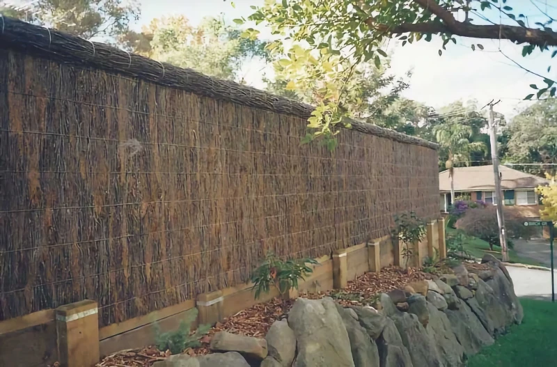 brushwood fence with rock wall